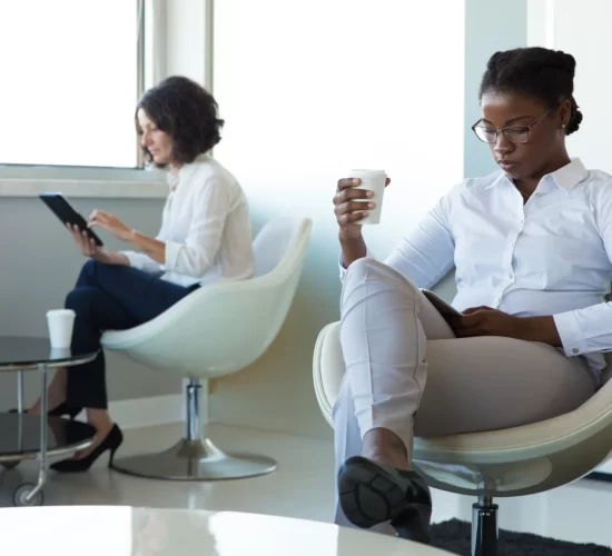 diverse-businesswomen-with-gadgets-drinking-coffee